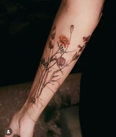 a woman's arm with flowers and leaves tattooed on the left side of her body