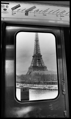 the eiffel tower is seen through a window on a train in black and white