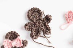 three crocheted items are shown on a white surface, one is pink and the other is brown