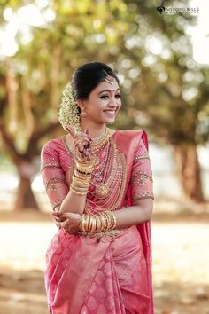 a woman in a pink sari and gold jewelry