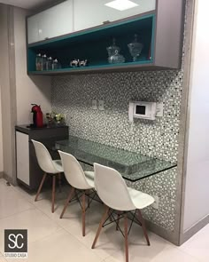 a glass table with four white chairs in front of a built - in microwave oven