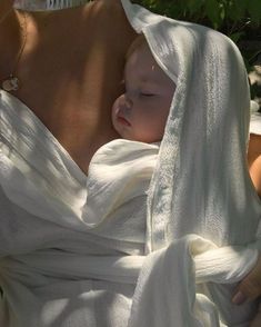 a woman holding a baby wrapped in a towel