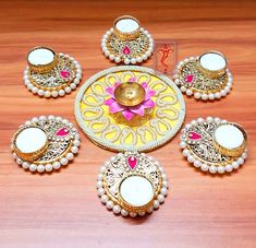 a wooden table topped with lots of different types of candles and plates on top of it