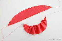 a piece of red fabric is being sewn together to make an ornament