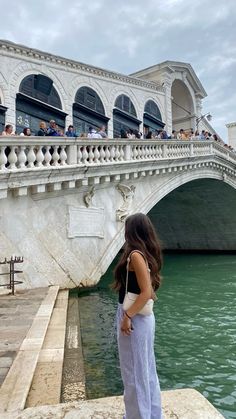 a woman standing on the edge of a bridge