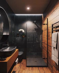 a modern bathroom with black walls and wood flooring