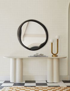 a white table with a mirror on it next to a black and white checkered floor