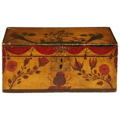 an old wooden box with flowers and birds painted on the side, sitting on a white surface