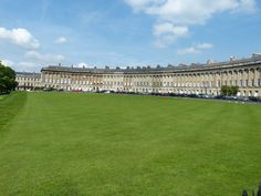 a large grassy field in front of an old building