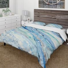 a bed with blue and white comforter in a bedroom