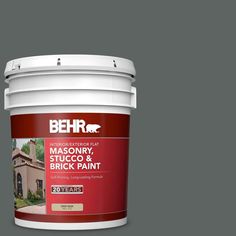 a gallon of behr masonry stucco and brick paint on a dark blue background with white trim