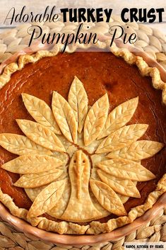 there is a pumpkin pie with leaves on the top and bottom in a brown bowl