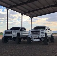 two large trucks parked under a covered structure