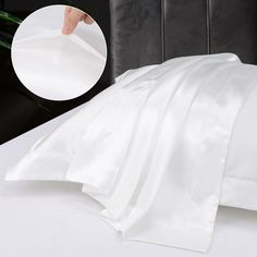 a bed with white sheets and a black headboard