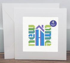 a cross stitch card with the words home on it and a house in the middle