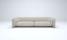 a white couch sitting on top of a white floor next to a wall with a light colored background