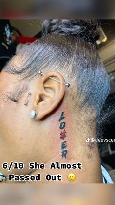 the back of a man's head with ear piercings and words on it