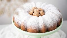 a bundt cake with powdered sugar on top is sitting on a green plate