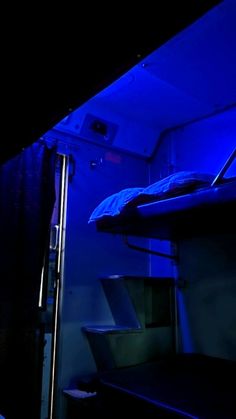 a bunk bed in a dark room with blue lights