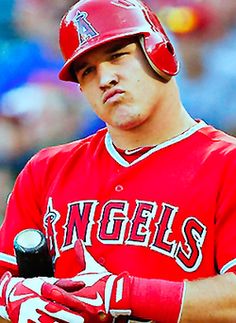 a baseball player holding a bat in his hand and wearing a red uniform with white lettering on it