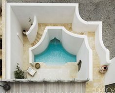 an aerial view of a swimming pool with steps leading up to the top floor and above ground