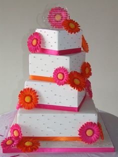 a three tiered cake with pink and orange flowers