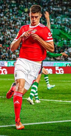 a man kicking a soccer ball on top of a field