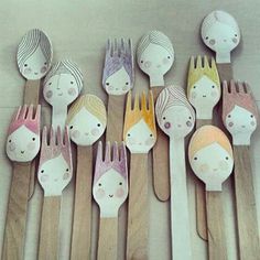 wooden spoons and forks with faces painted on them are lined up in the shape of people's heads