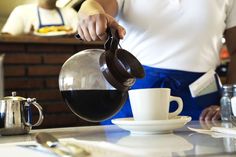 a person pours coffee into a cup