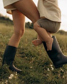 two people standing in the grass with their feet up on each other's legs