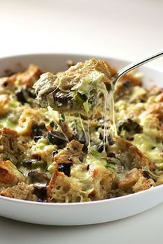 a casserole dish with broccoli, mushrooms and cheese being drizzled over it