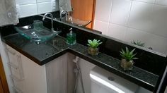 a bathroom sink with a glass bowl on the counter top next to a white toilet