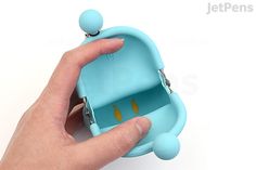 a hand is holding a small blue case