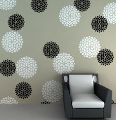 a chair sitting in front of a wall with black and white flowers on it's side