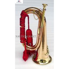 a brass plated musical instrument with red strings and bells on it's stand