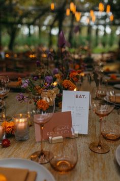 the table is set with wine glasses and place cards for guests to sit down at