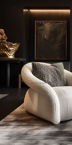 a white chair sitting on top of a wooden floor next to a table with a gold vase