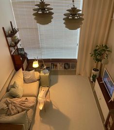 an overhead view of a living room with couches and lamps on the windowsill