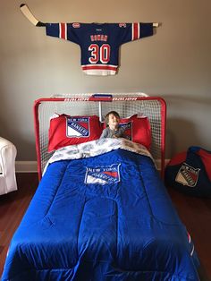 a young boy is laying in his bed with the jersey on top of him,