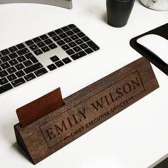 a wooden name plate sitting on top of a desk next to a keyboard and mouse