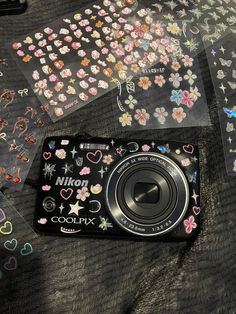 a camera sitting on top of a table next to some stickers and paper decorations