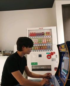 a young man sitting in front of a vending machine