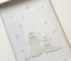 two snowmen are sitting in the middle of a white frame