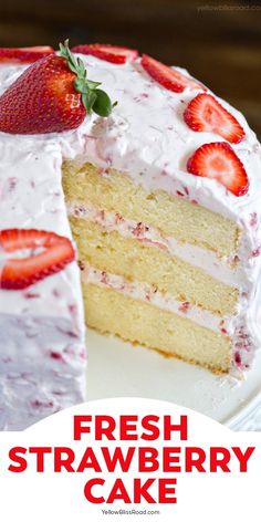 a cake with white frosting and strawberries on top is cut in half to show the layers