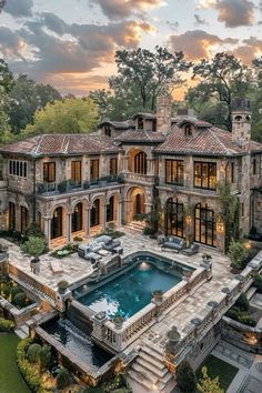 an aerial view of a large mansion with a pool in the foreground and stone steps leading up to it