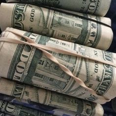 stacks of rolled up dollar bills tied together