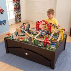 a young boy playing with his toy train set