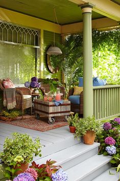 a porch with potted plants and furniture on it