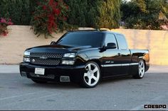 a black truck parked in front of a wall