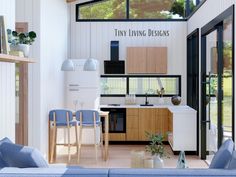 a living room filled with furniture next to a kitchen